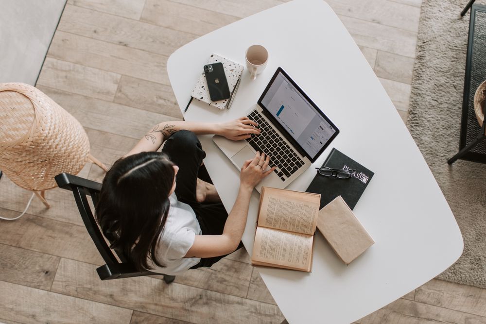 A professional concentrating on work with a laptop and open notebook